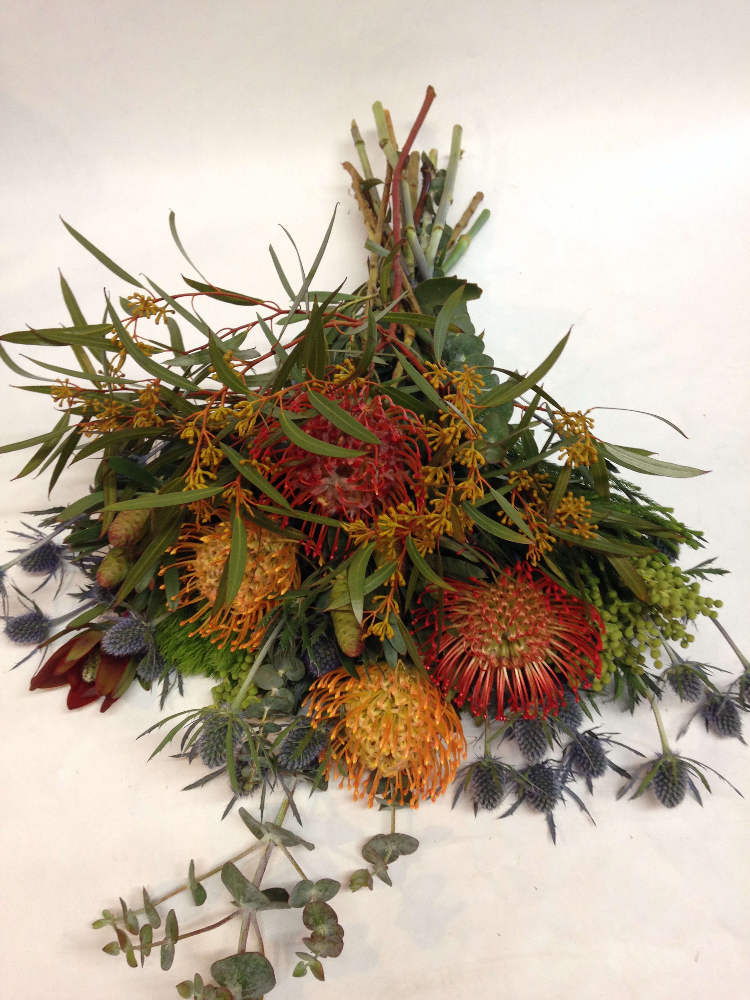 Mixed bouquet with red, orange, and yellow pincushion-like blooms