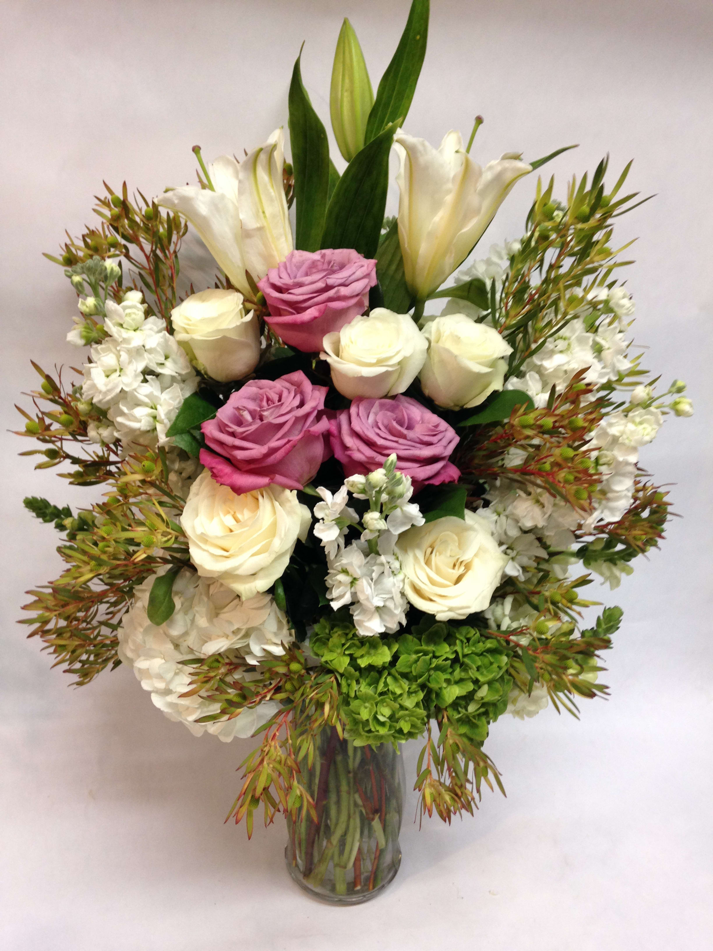 Just Like Heaven - This arrangement comes complete with lavender and white roses, casa blanca lilies, white stock, green hydrangea and safari branches.  (Some flowers may be subject to change depending on the season.  We will contact you with available flower substitutions; please contact us with specific questions if you are concerned with flower availability, thanks!)  FEATURED ARRANGEMENT: $350.00 (REGULAR PRICE)