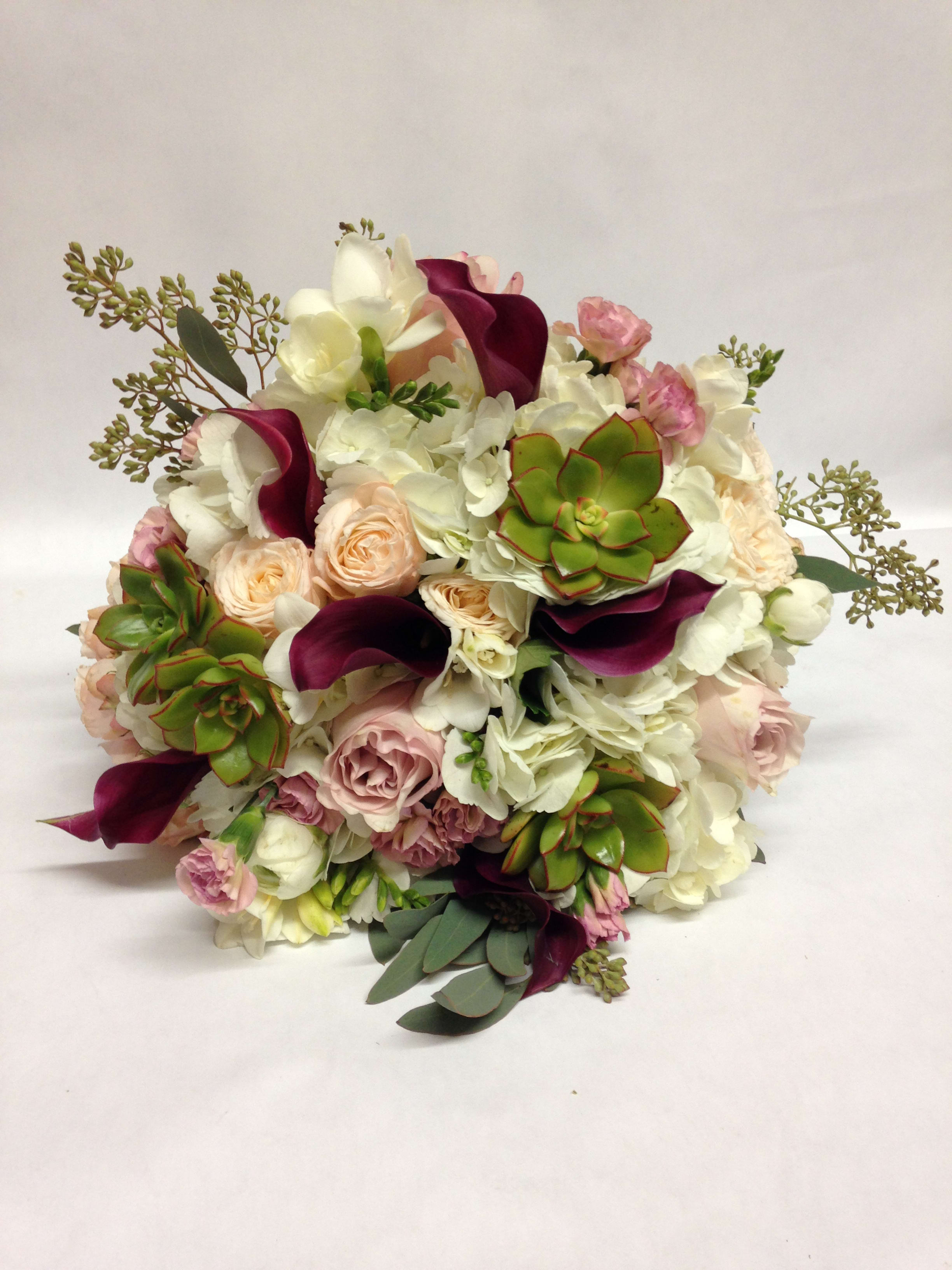 Bouquet of white and blush flowers with burgundy calla lilies and succulents