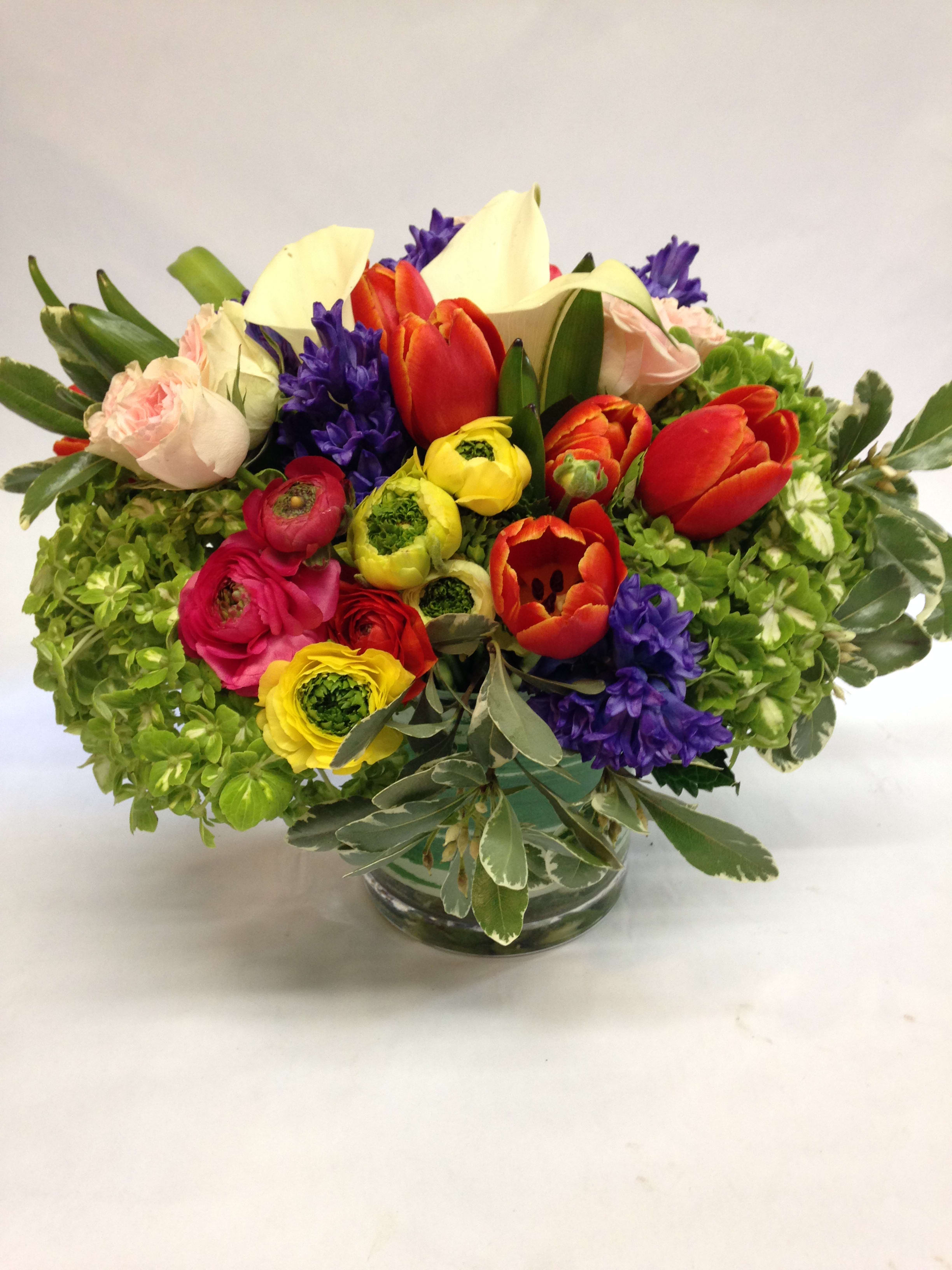 Colorful mixed flower arrangement in a clear glass vase