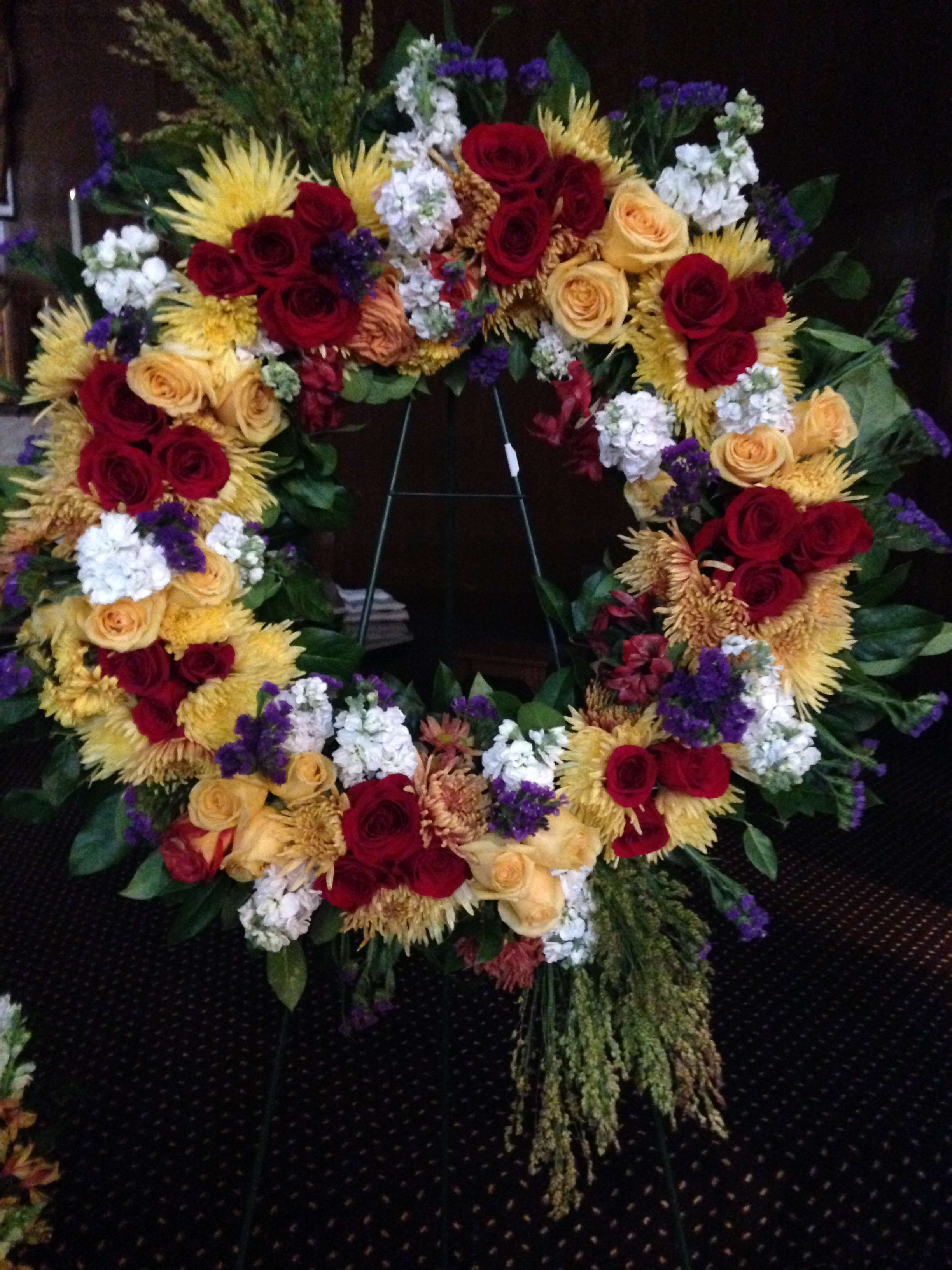 Large floral wreath with red and yellow roses and white accents