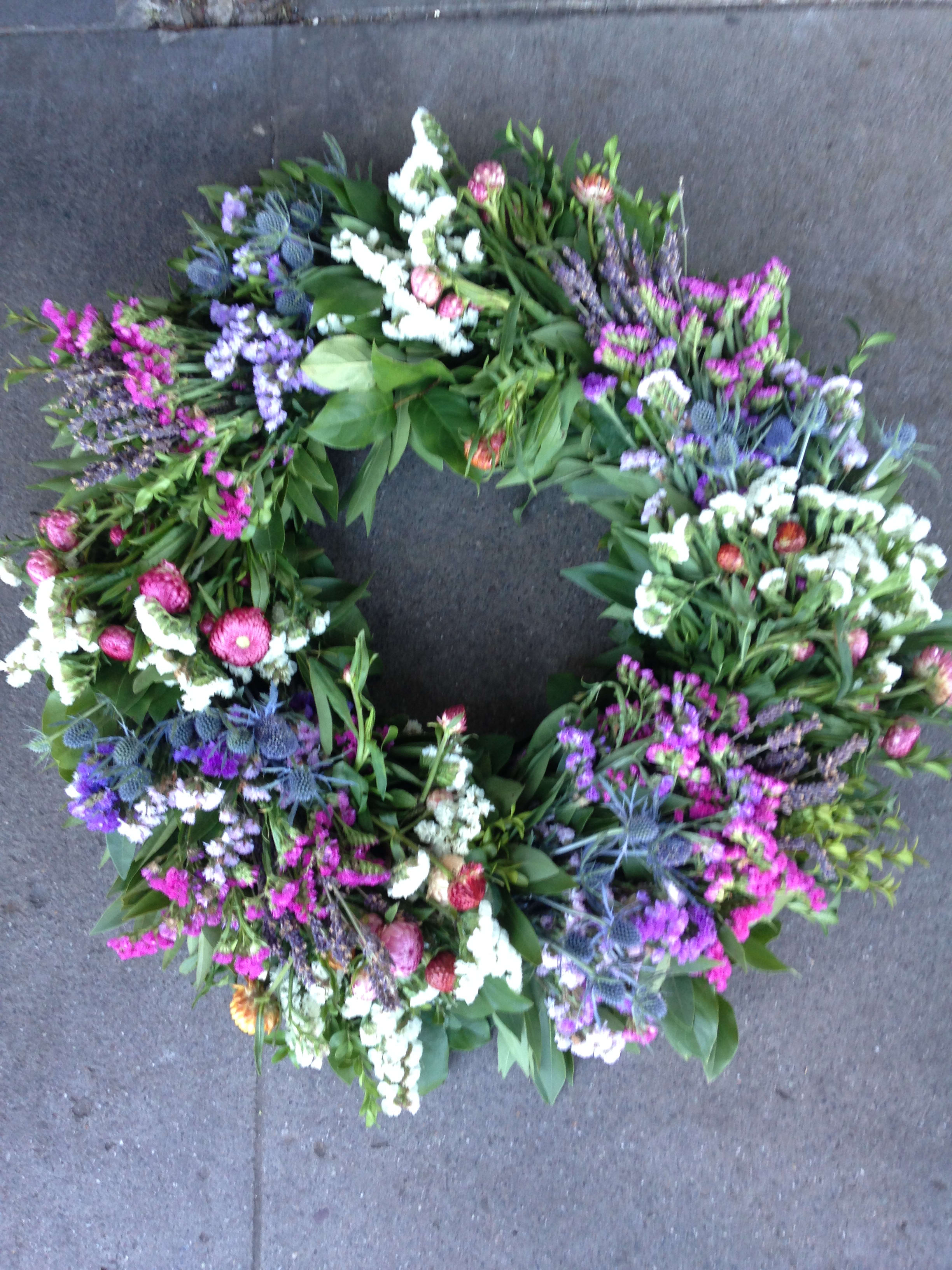 Circular floral wreath with purple, pink, and white blooms