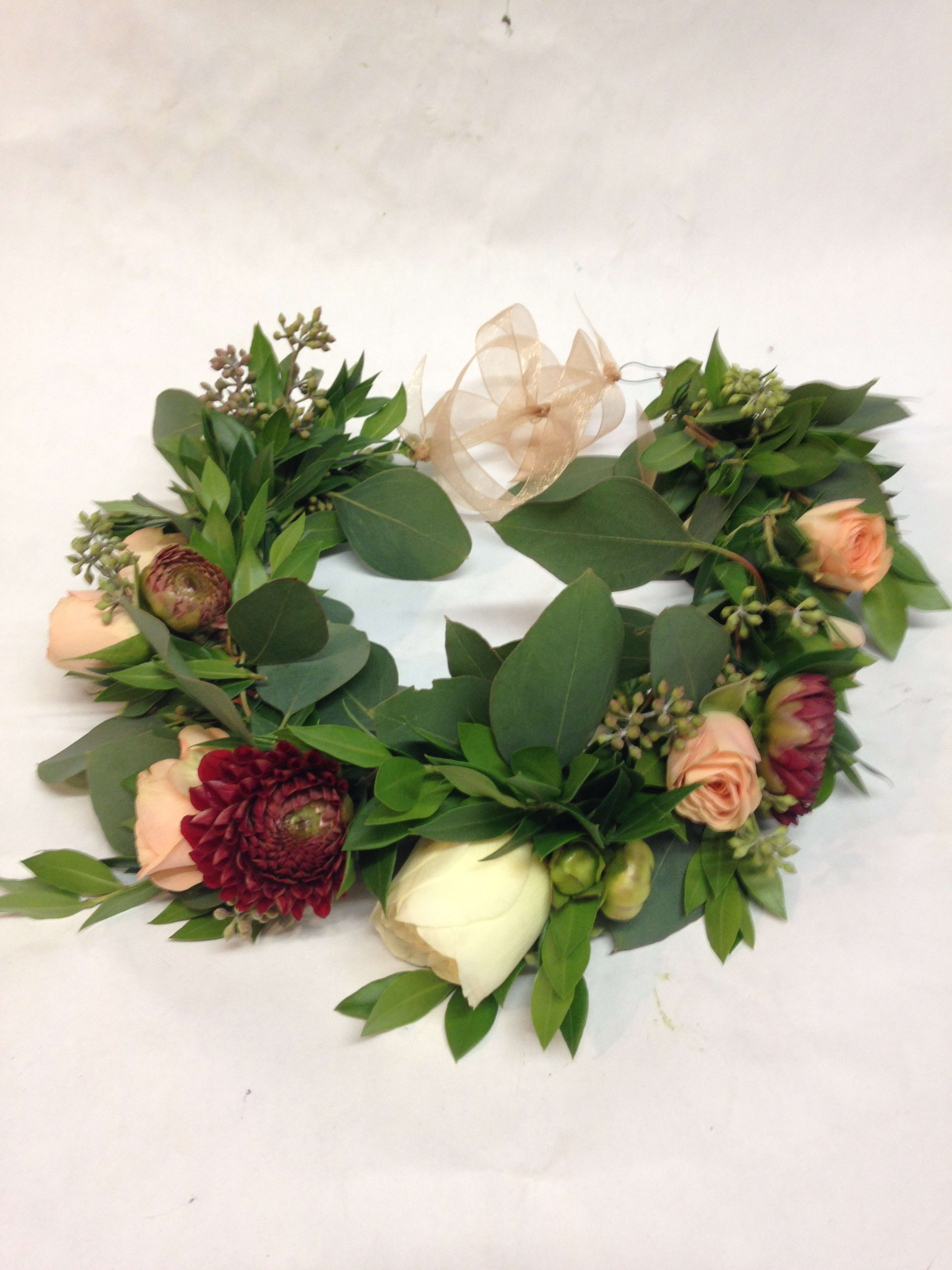 Floral wreath with peach and burgundy blooms and a sheer ribbon bow
