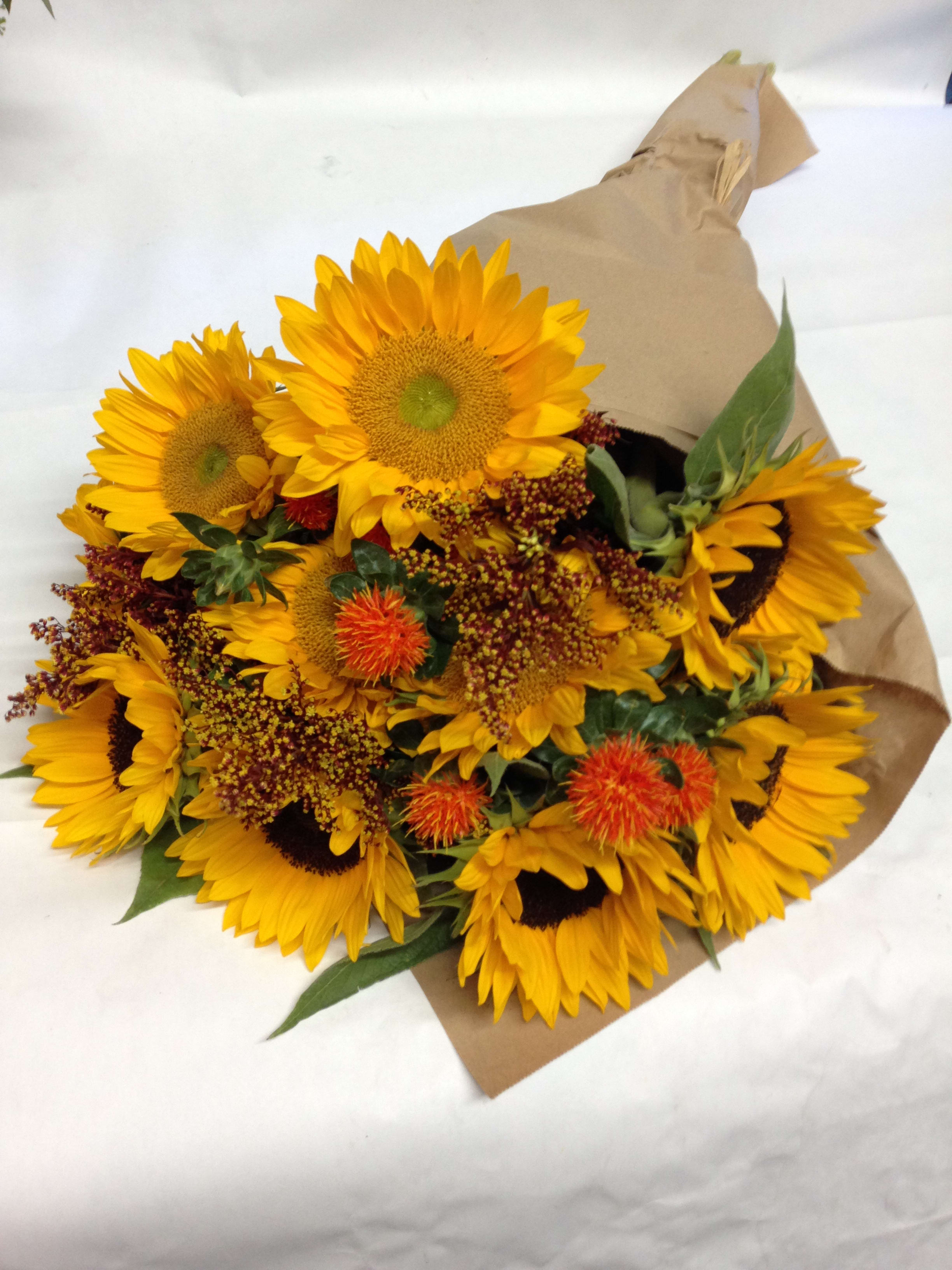Bouquet of yellow sunflowers wrapped in brown paper