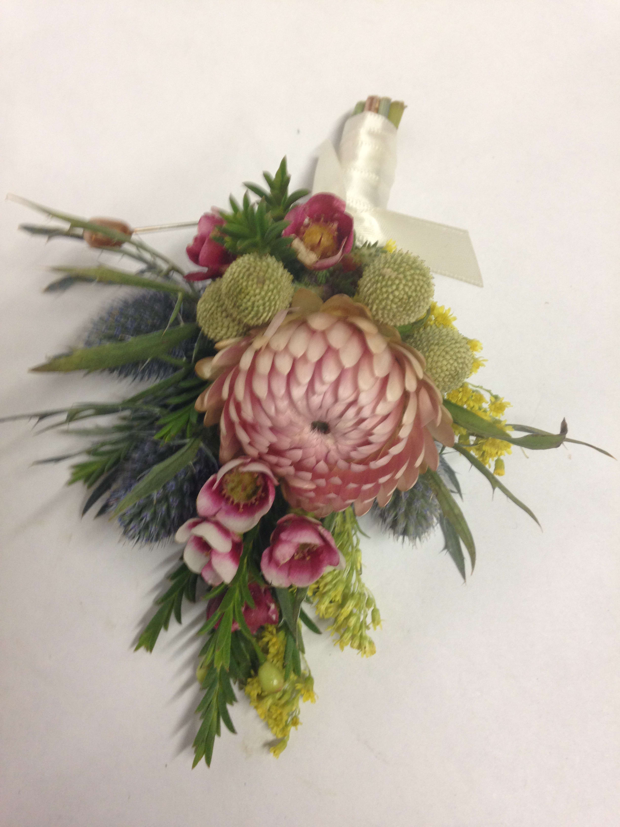 Pink and green floral corsage with a large central bloom