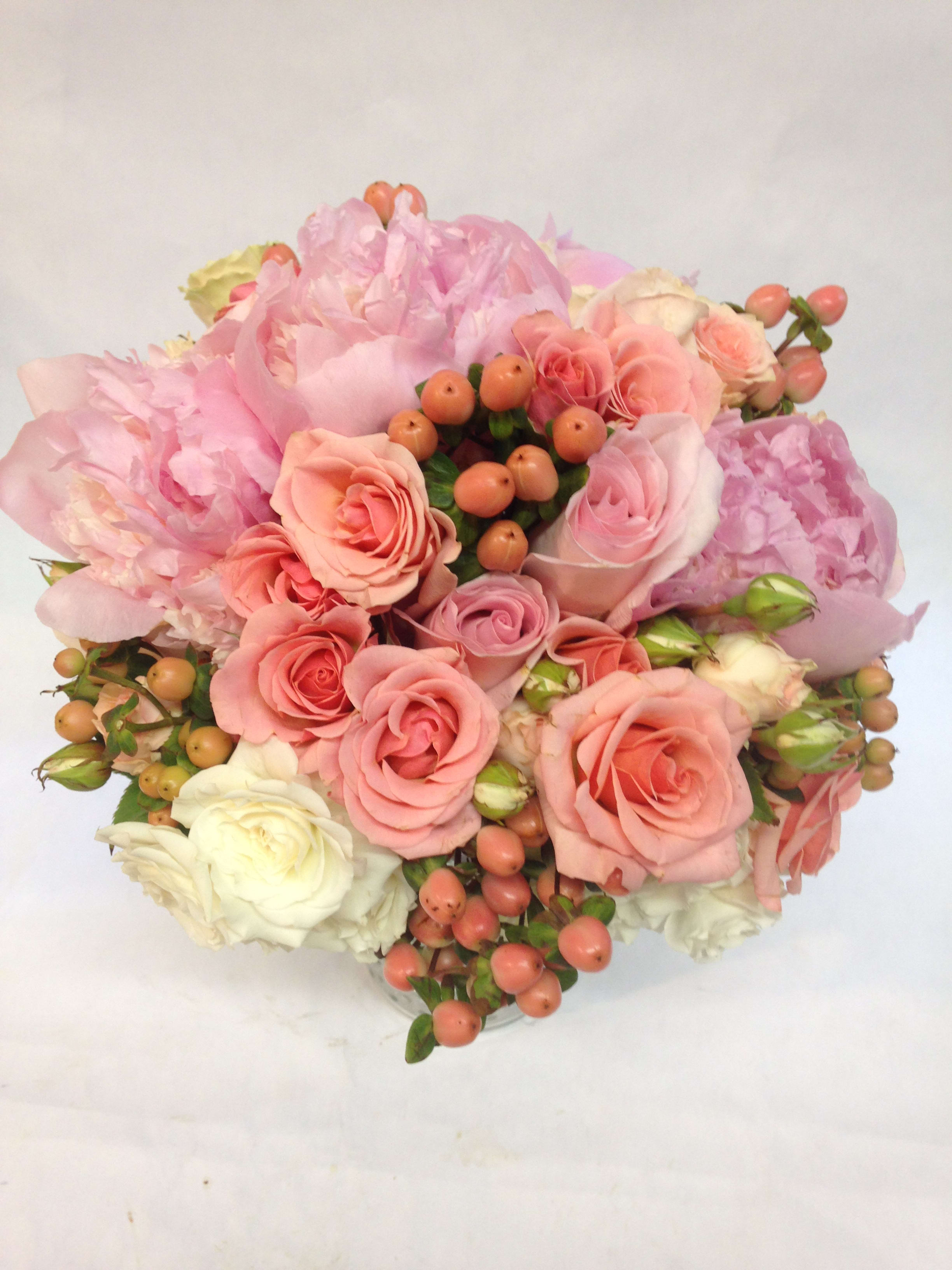Pink and peach rose bouquet with pale peonies and berry accents
