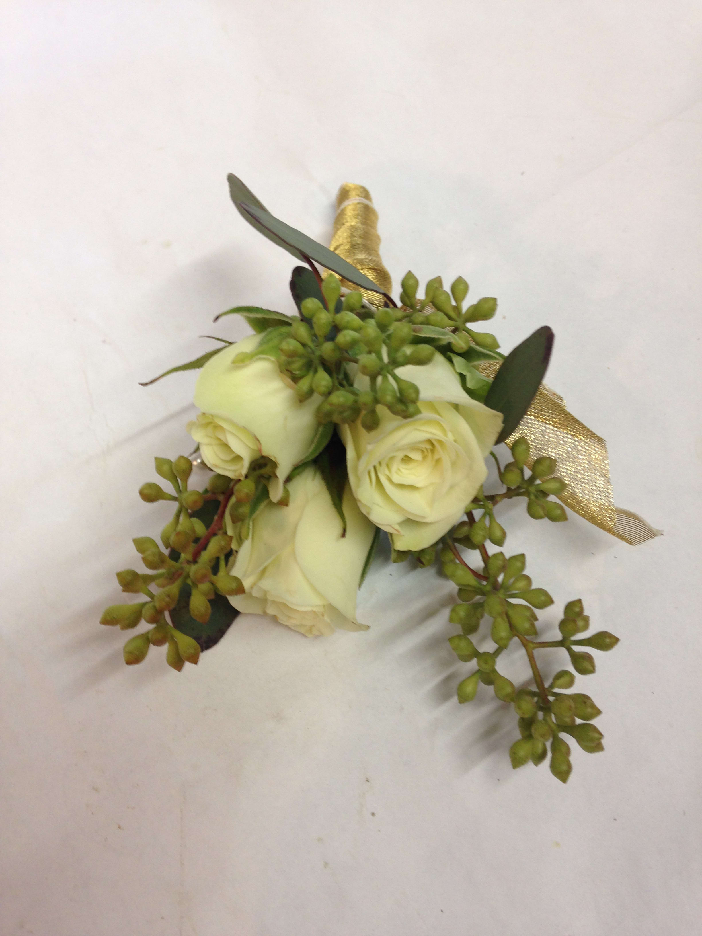 Small white rose boutonniere with green foliage and gold ribbon