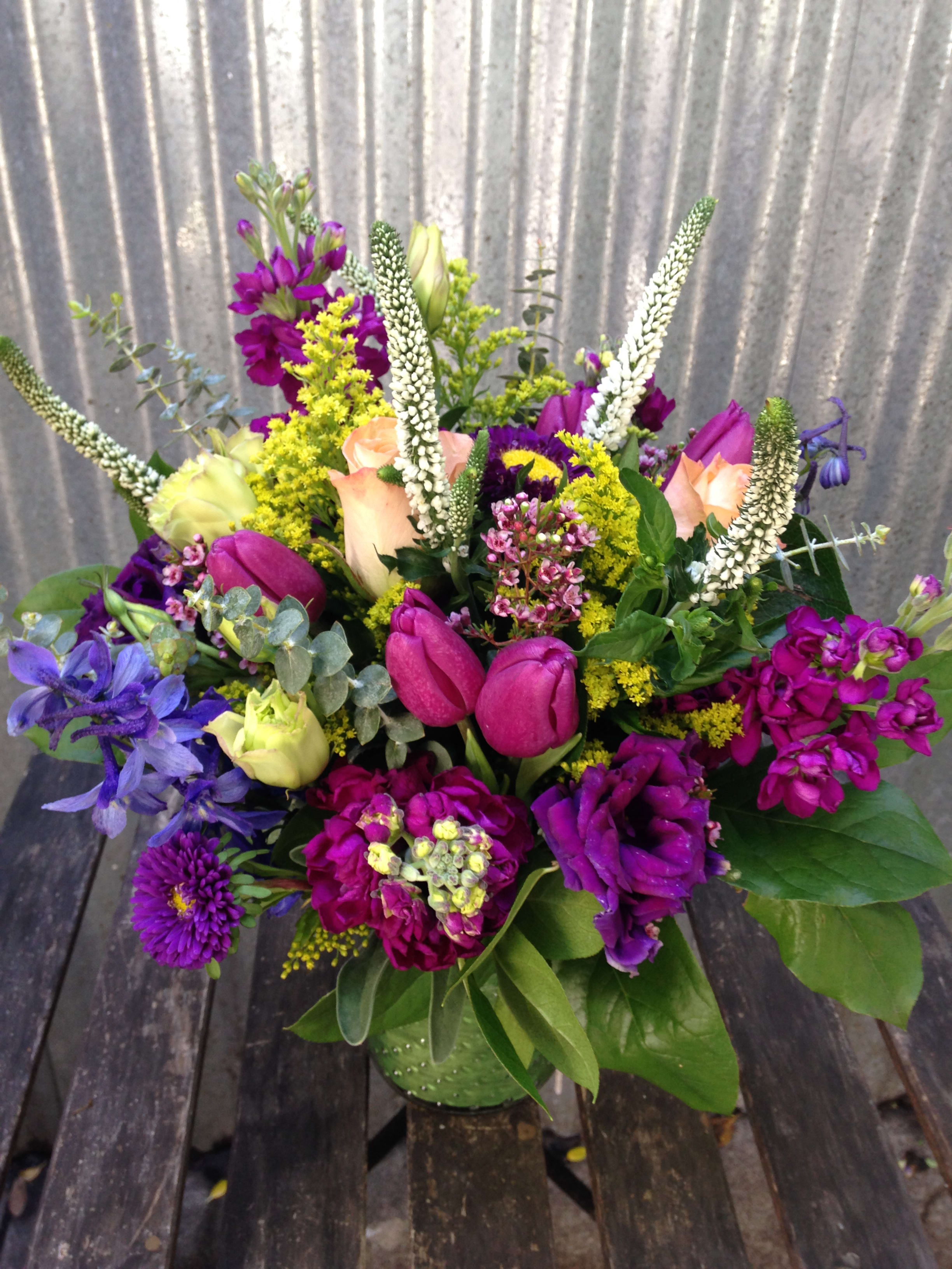 Mixed bouquet with purple, pink, and yellow flowers in a vase