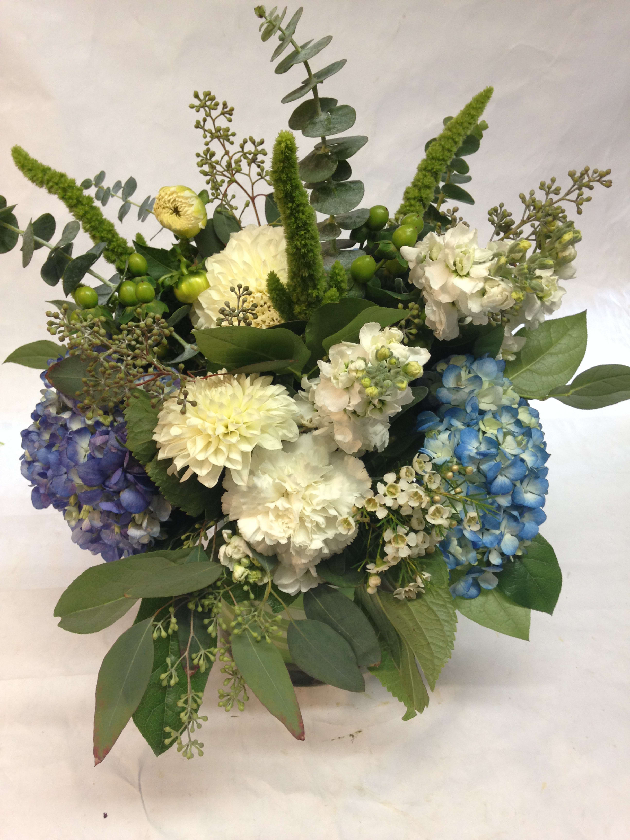Mixed bouquet with blue, purple, and white hydrangeas and greenery