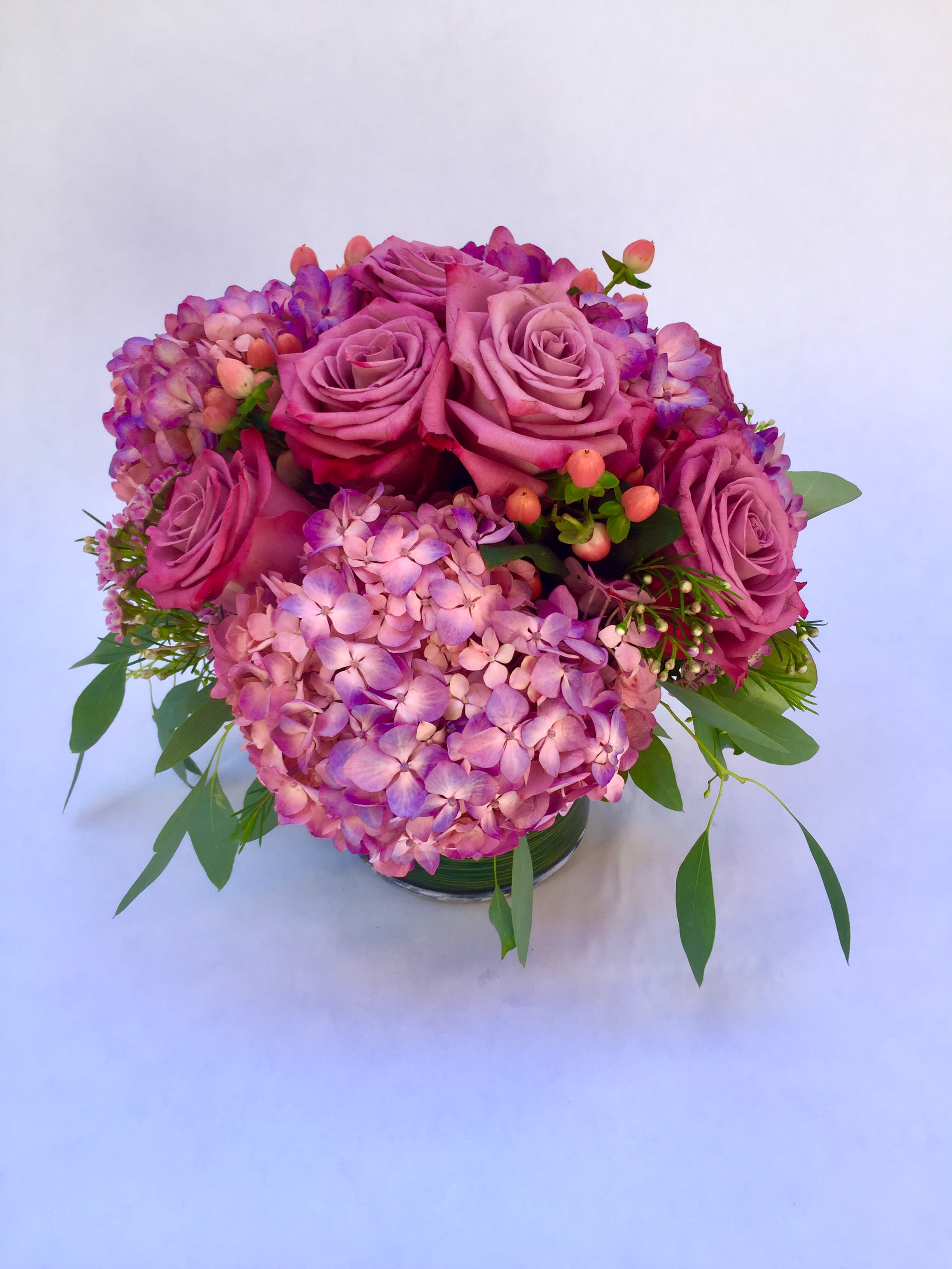 Pink roses and hydrangeas arranged in a low glass vase