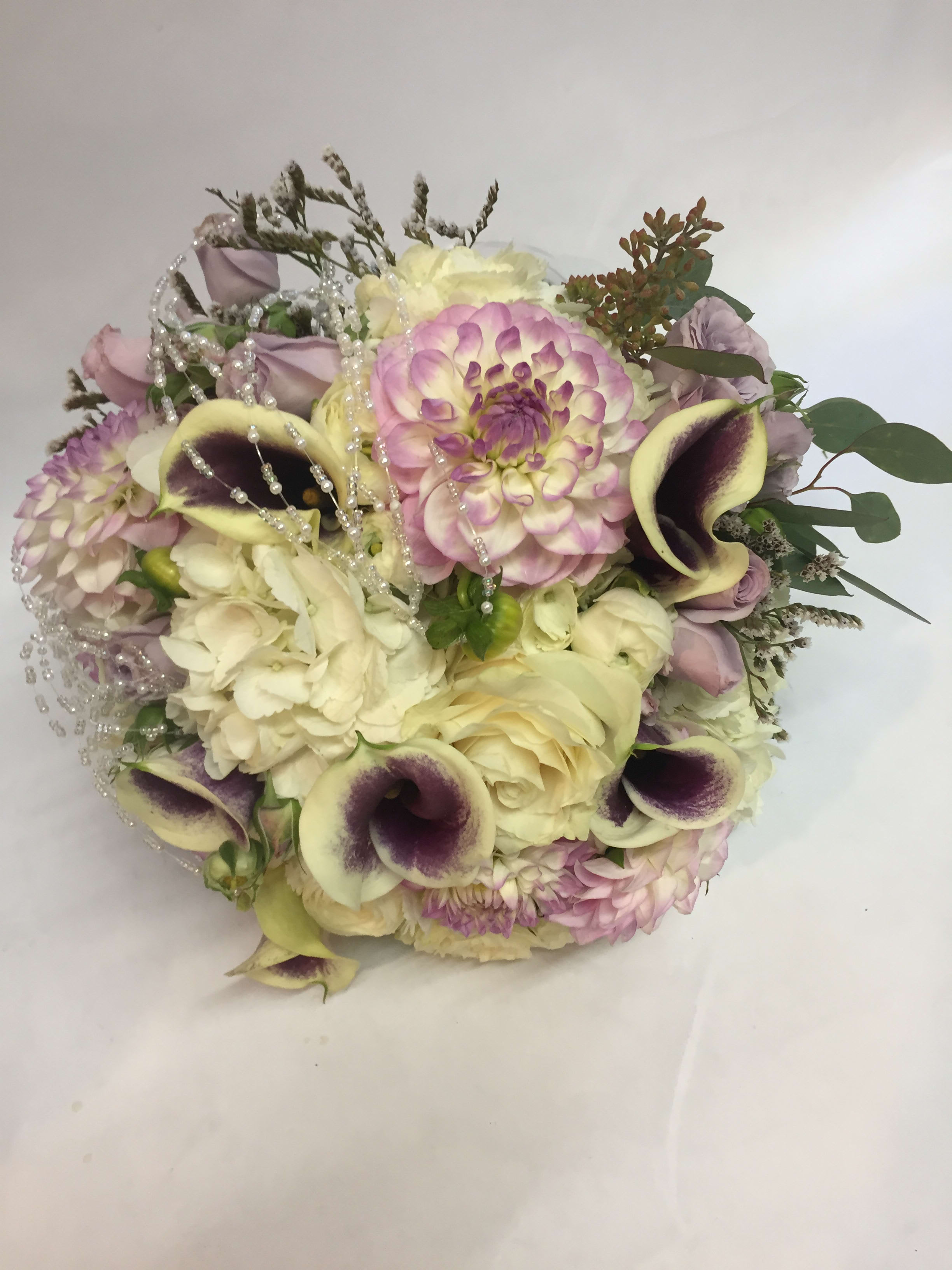 Bouquet of cream, pink, and purple flowers with pearl strands