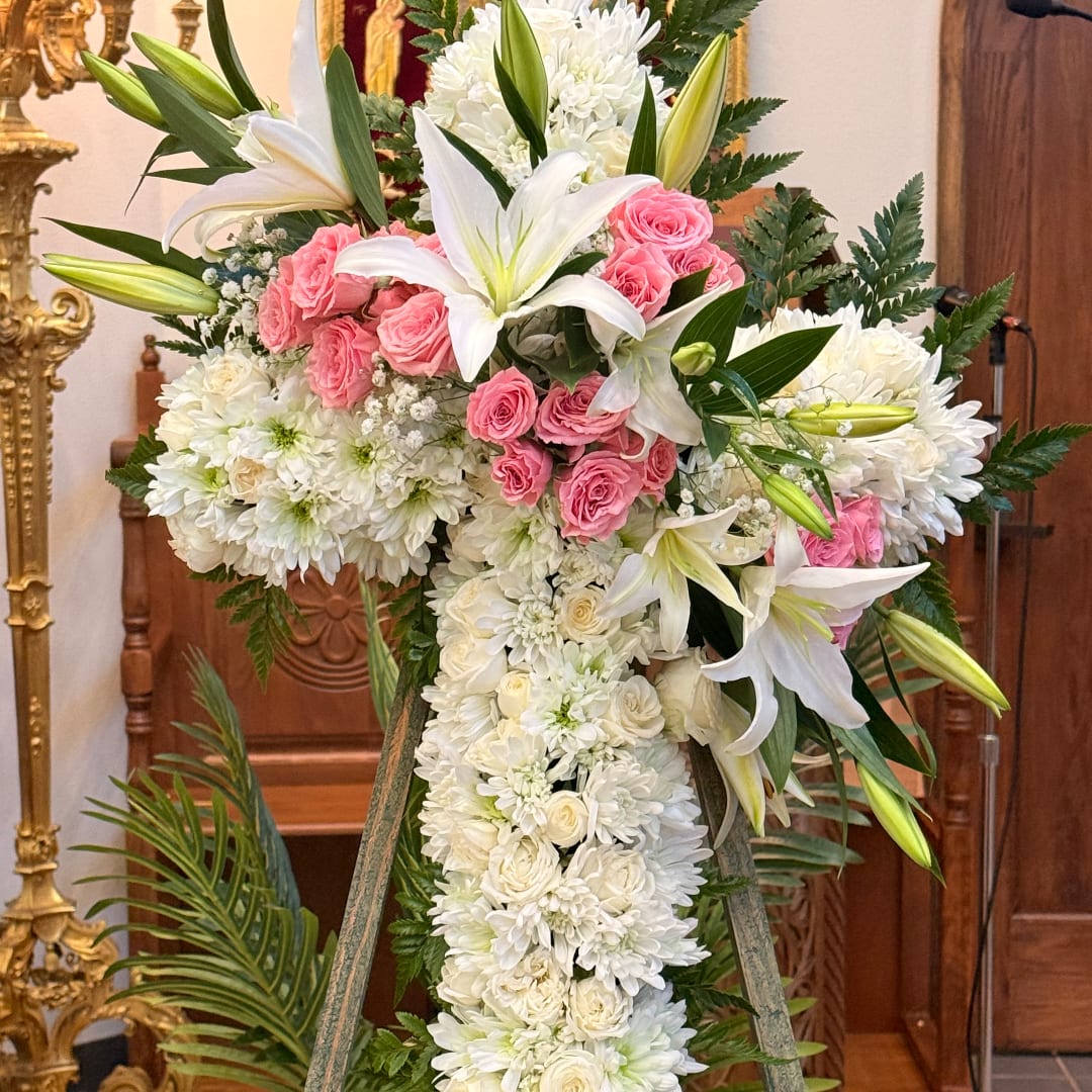 White floral standing cross with pink roses and lilies