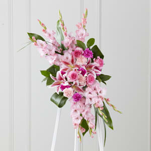 Pink floral standing spray on a white easel