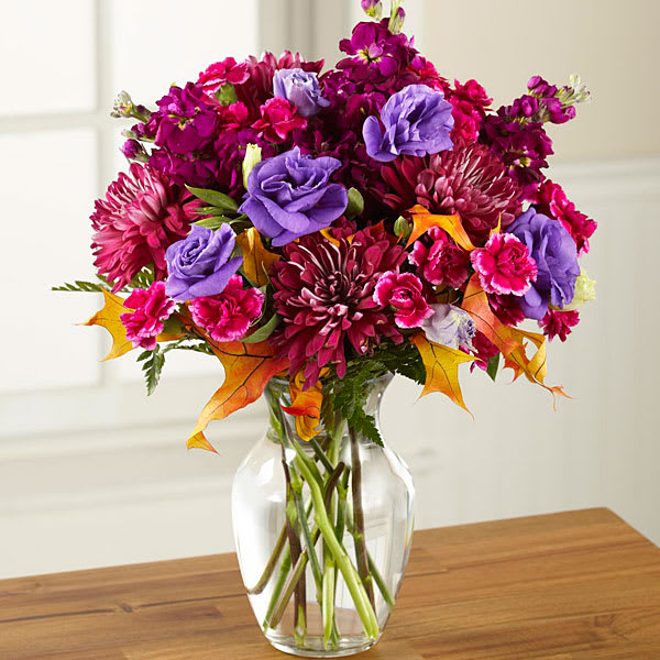 Bouquet of magenta and purple flowers in a clear glass vase