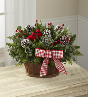 Holiday basket arrangement with pinecones, berries, and a red gingham bow