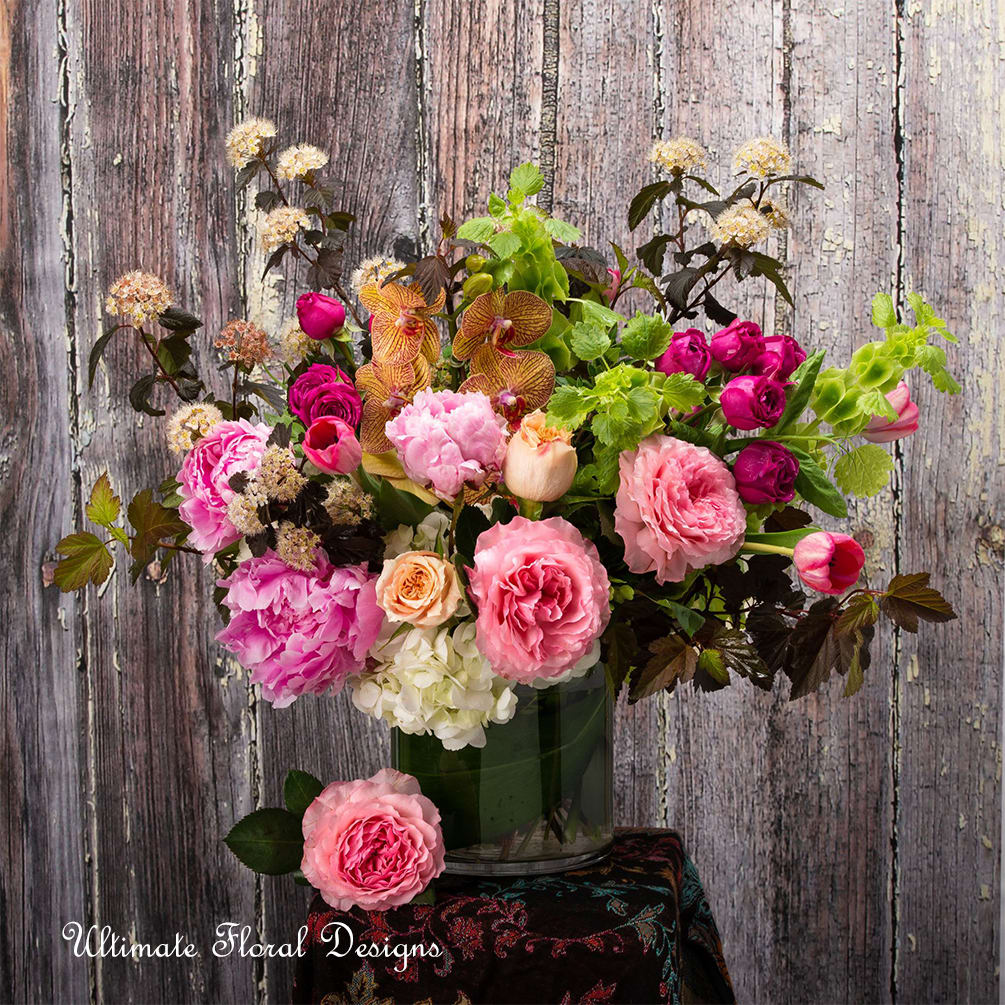 Mixed pink and peach flowers in a glass vase