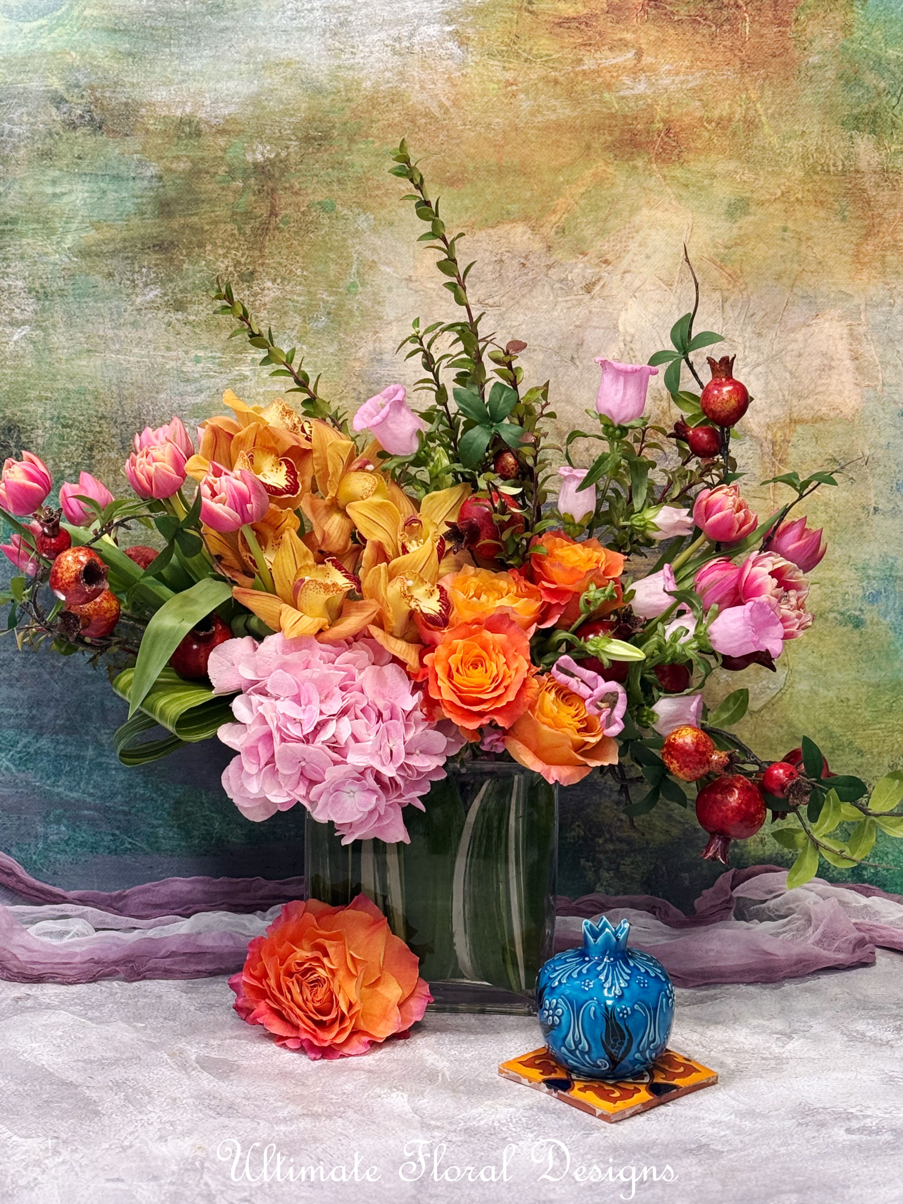 Colorful bouquet in a glass vase with roses, hydrangea, orchids, and tulips