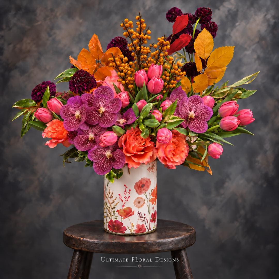 Colorful floral arrangement in a floral-print vase with pink tulips and purple orchids