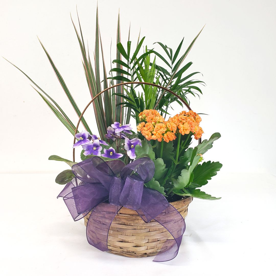 Basket arrangement with purple and orange flowers and a large purple ribbon