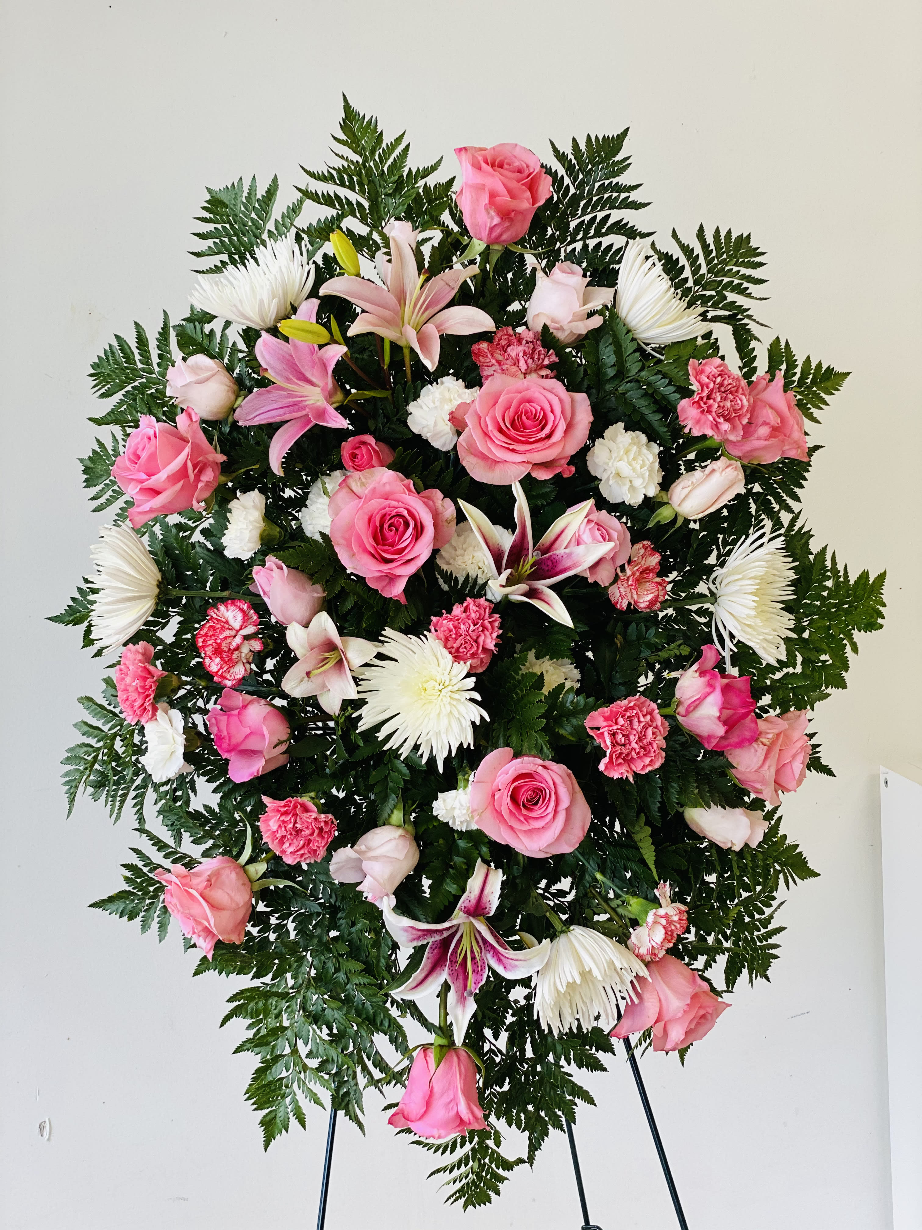 Standing floral spray with pink roses, lilies, and white chrysanthemums