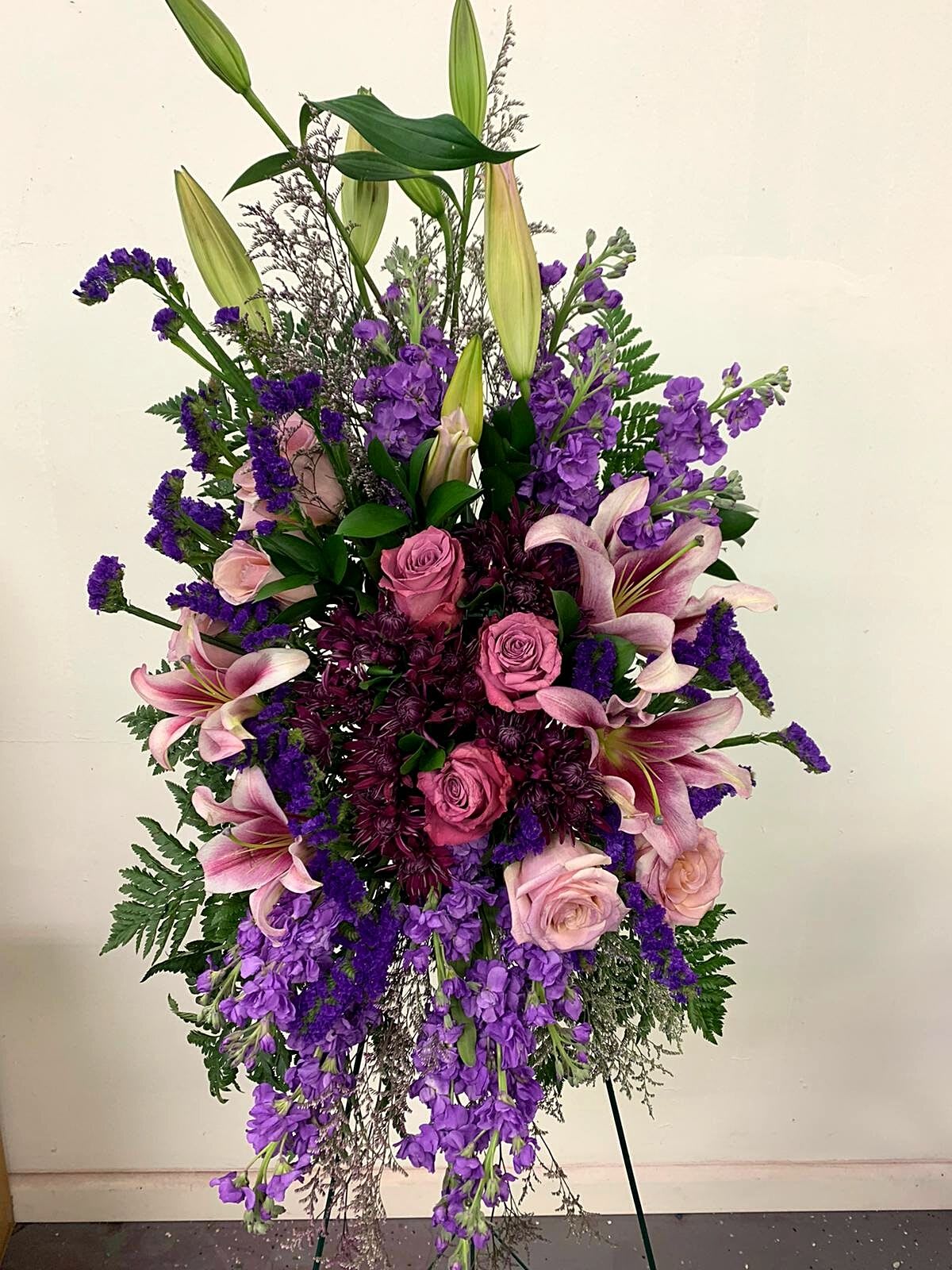 Tall standing arrangement of pink and purple flowers with lilies and roses