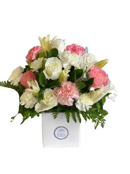 Pink and white floral arrangement in a white box