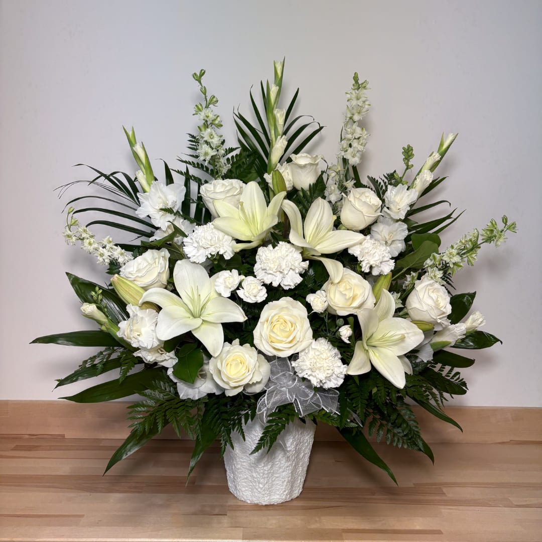 White roses and lilies arranged in a white vase