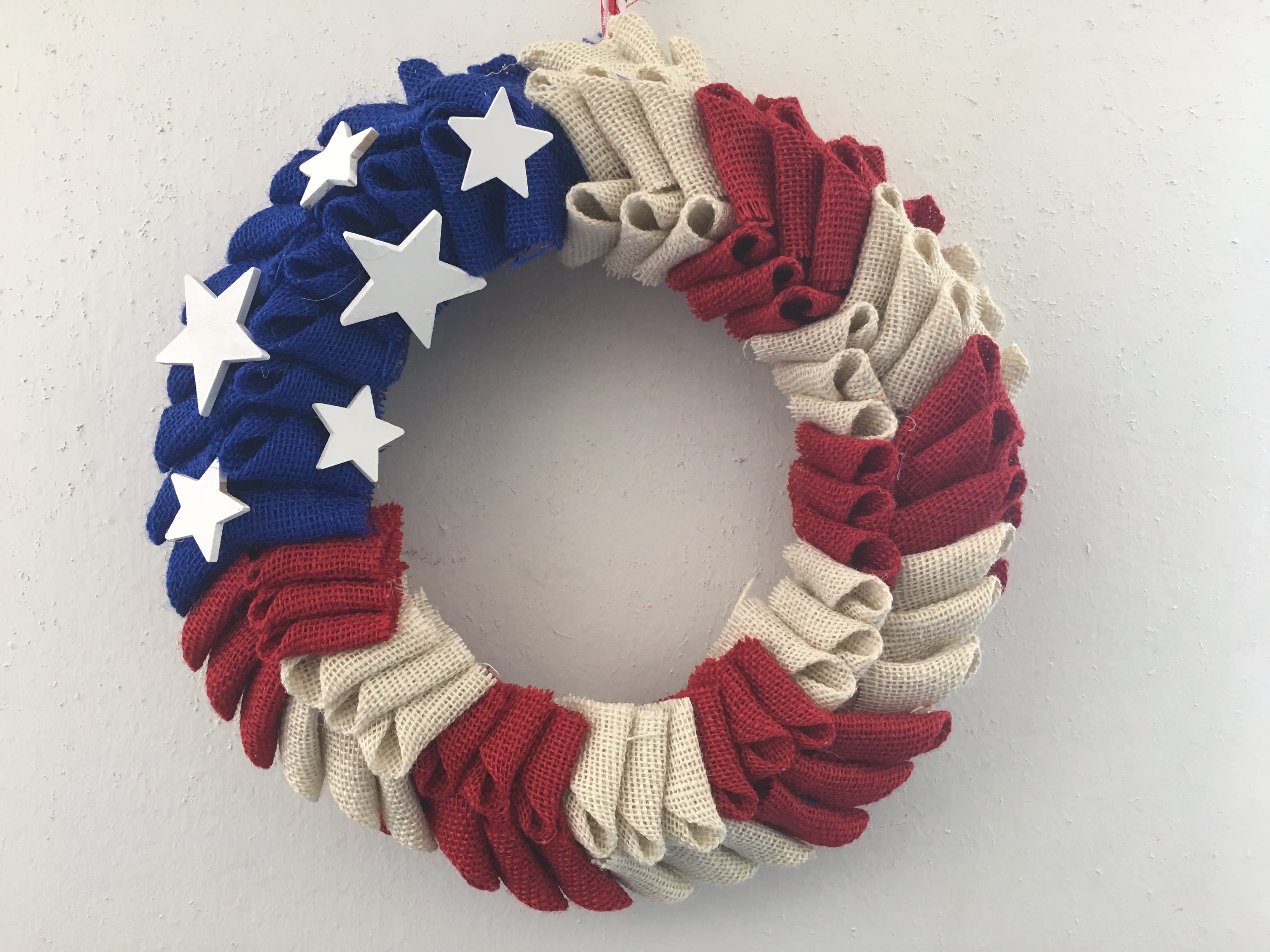 Patriotic wreath with red, white, and blue fabric folds and white stars
