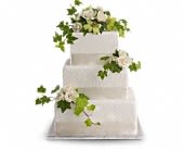 Three-tier white cake with white flowers and green ivy accents