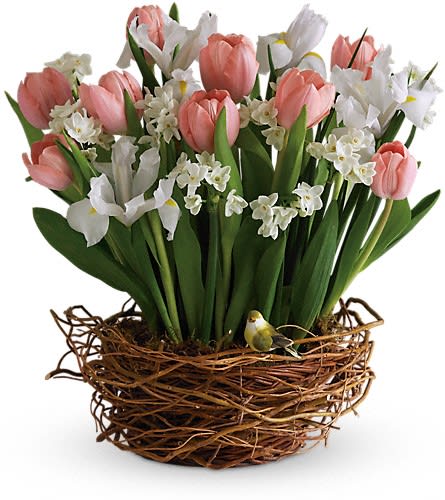 Pink tulips and white flowers arranged in a twig basket