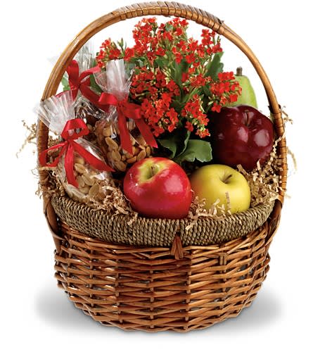 Gift basket with flowers, apples, pears, and wrapped snacks