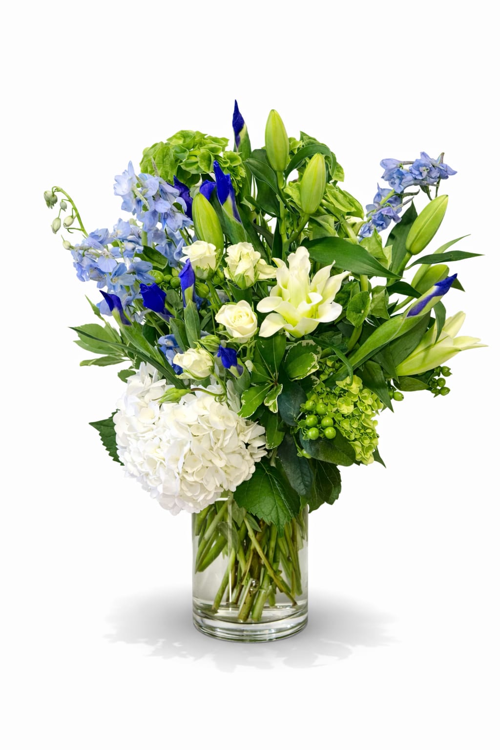 Blue and white mixed flower arrangement in a clear glass vase