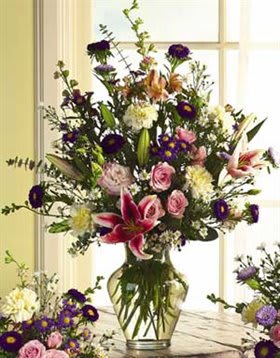 Tall mixed bouquet in a glass vase with pink roses and lilies