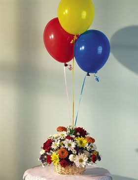 Basket of mixed flowers with red, yellow, and blue balloons