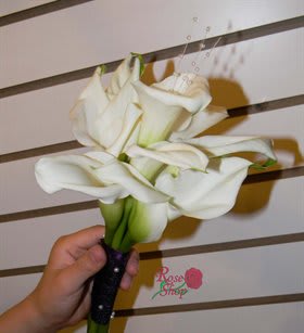 Handheld bouquet of white calla lilies with a dark wrapped stem