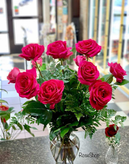 Hot pink roses arranged in a clear glass vase