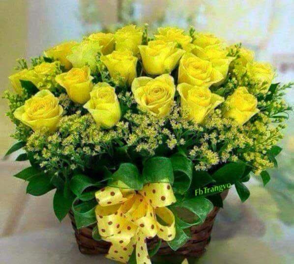 Yellow roses arranged in a basket with a yellow polka-dot bow