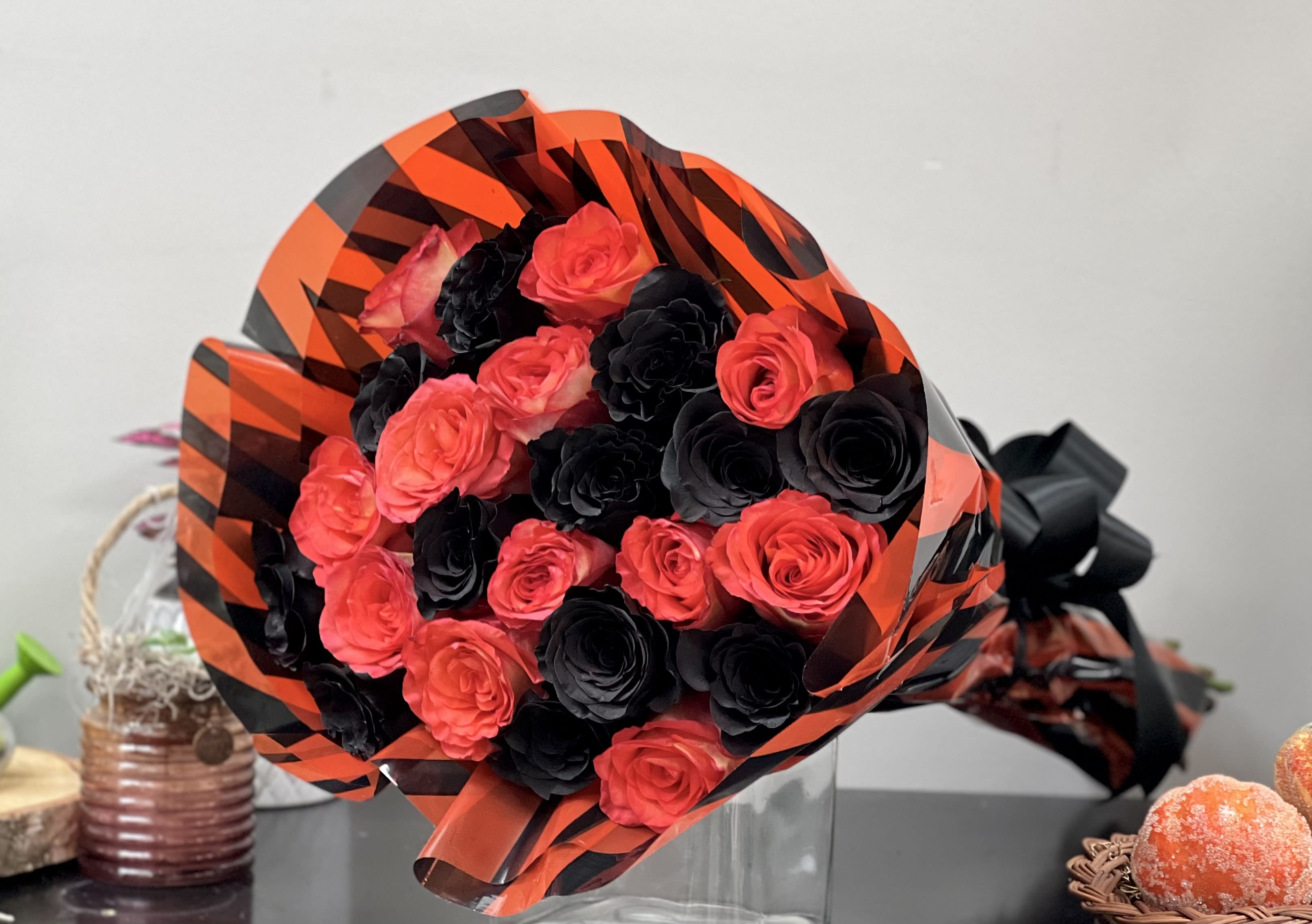 Bouquet of red and black roses wrapped in orange-and-black paper