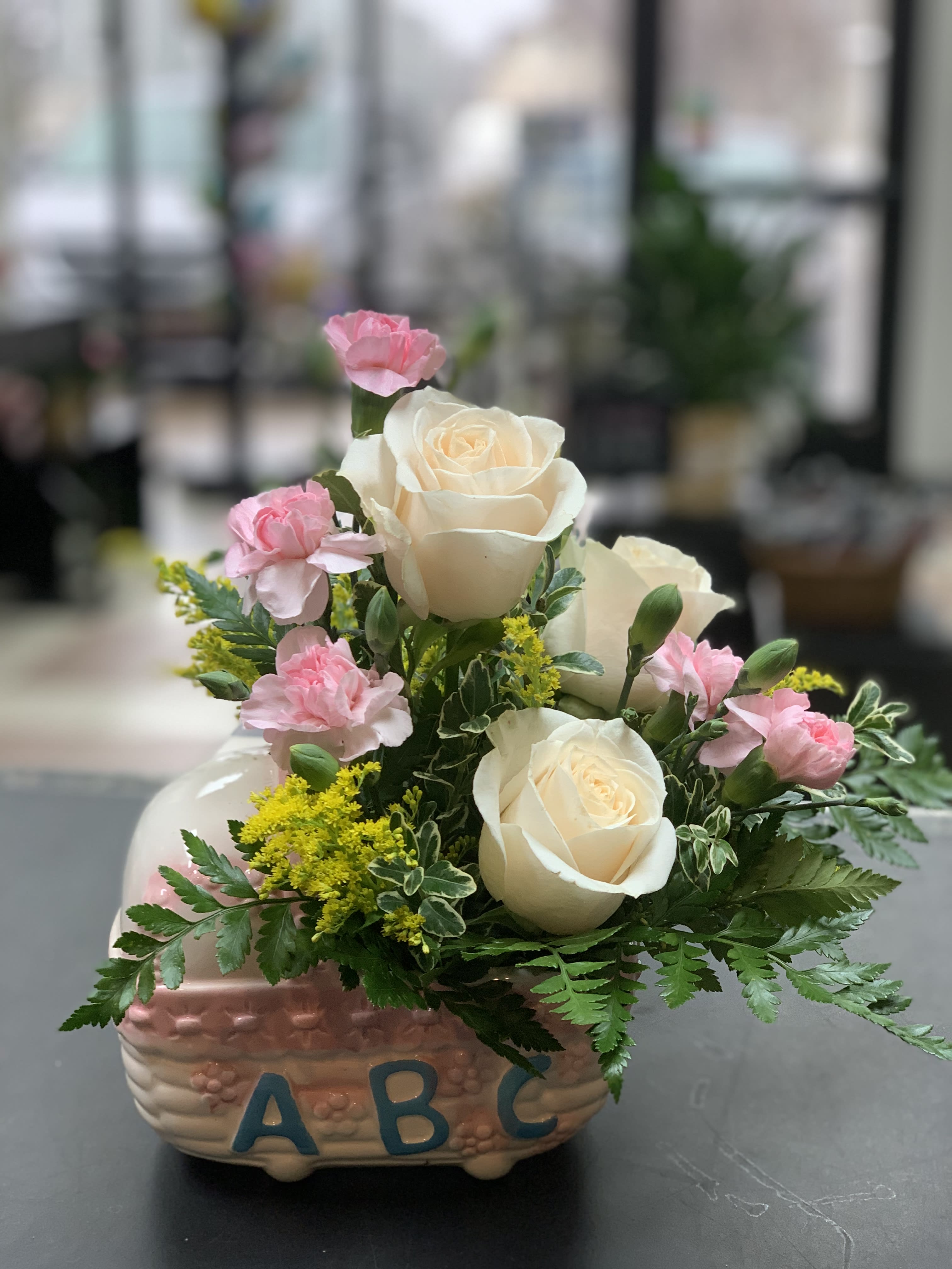 Pink carnations and white roses in a decorative ceramic container