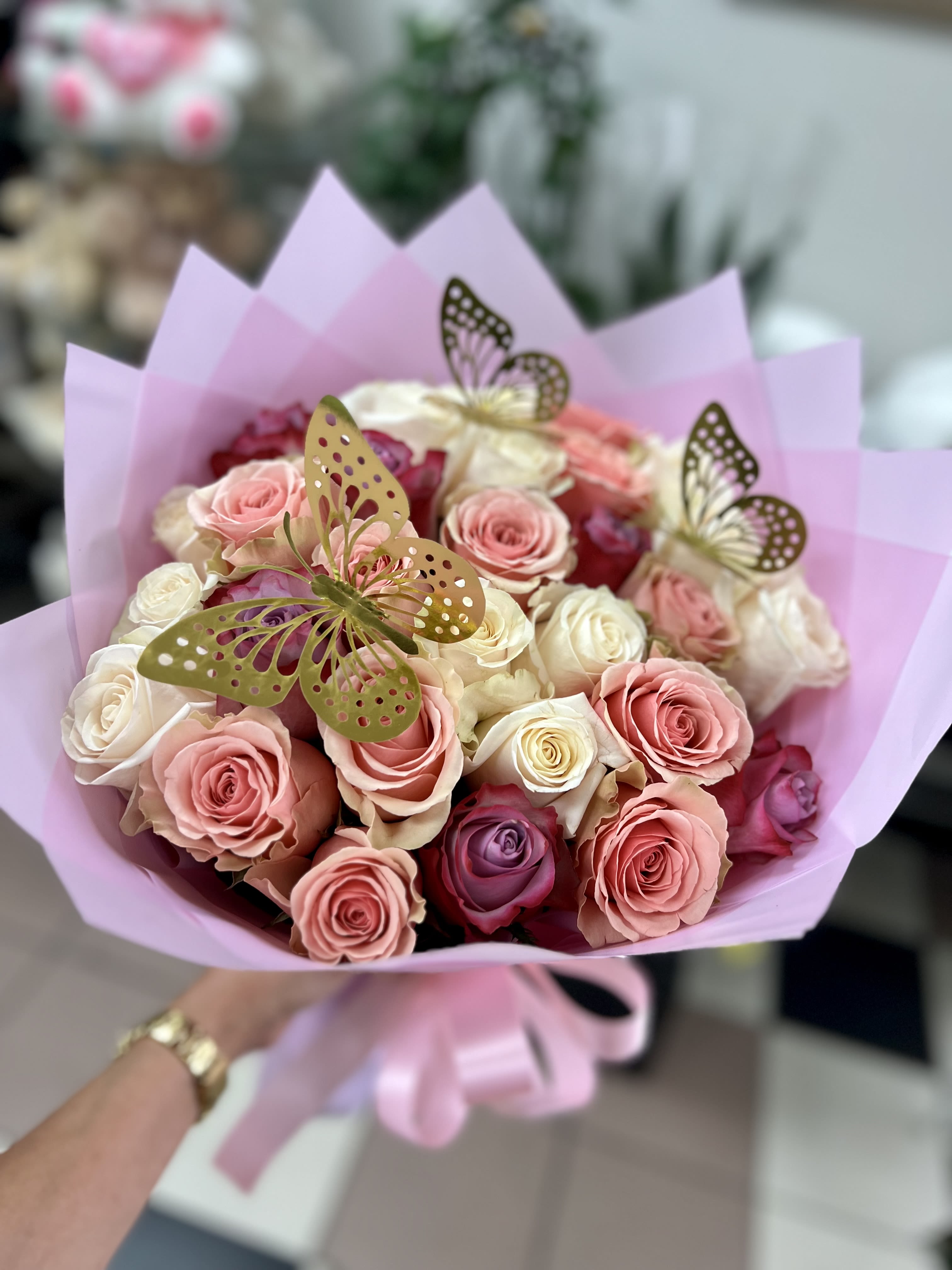 Bouquet of pink and white roses wrapped in lavender paper