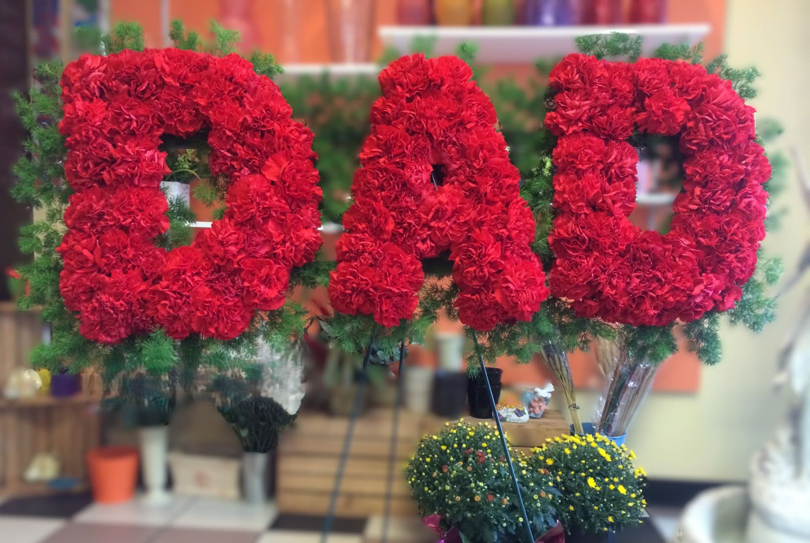 Large red floral letters spelling DAD with greenery accents