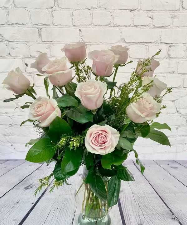 Bouquet of pale pink roses in a clear glass vase