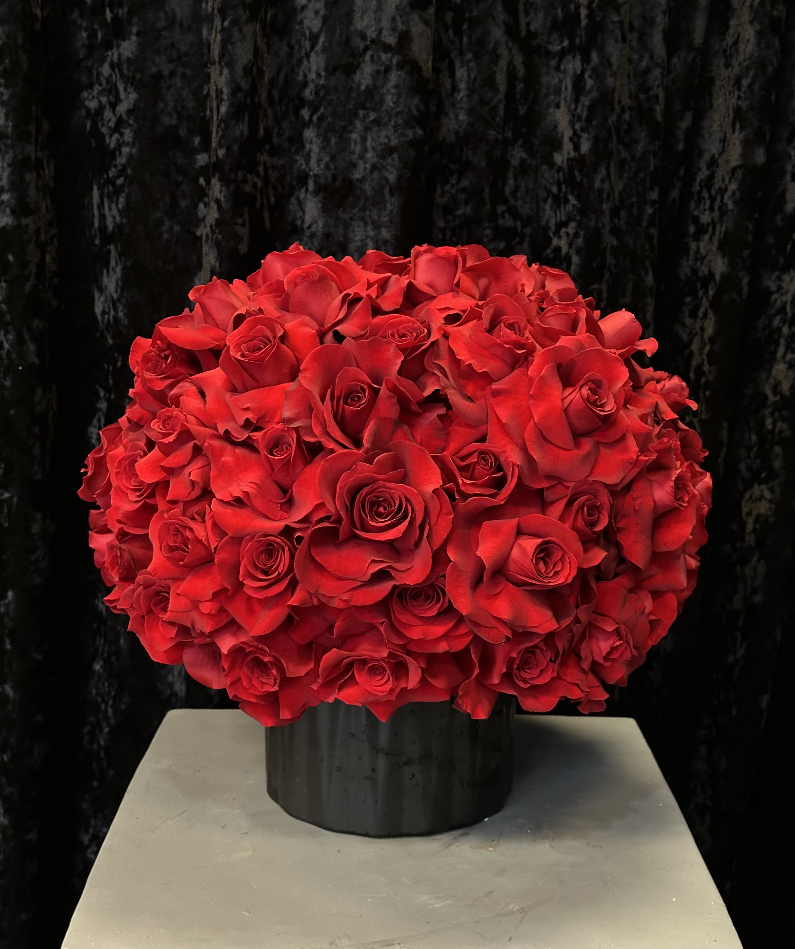 Large bouquet of red roses in a black vase