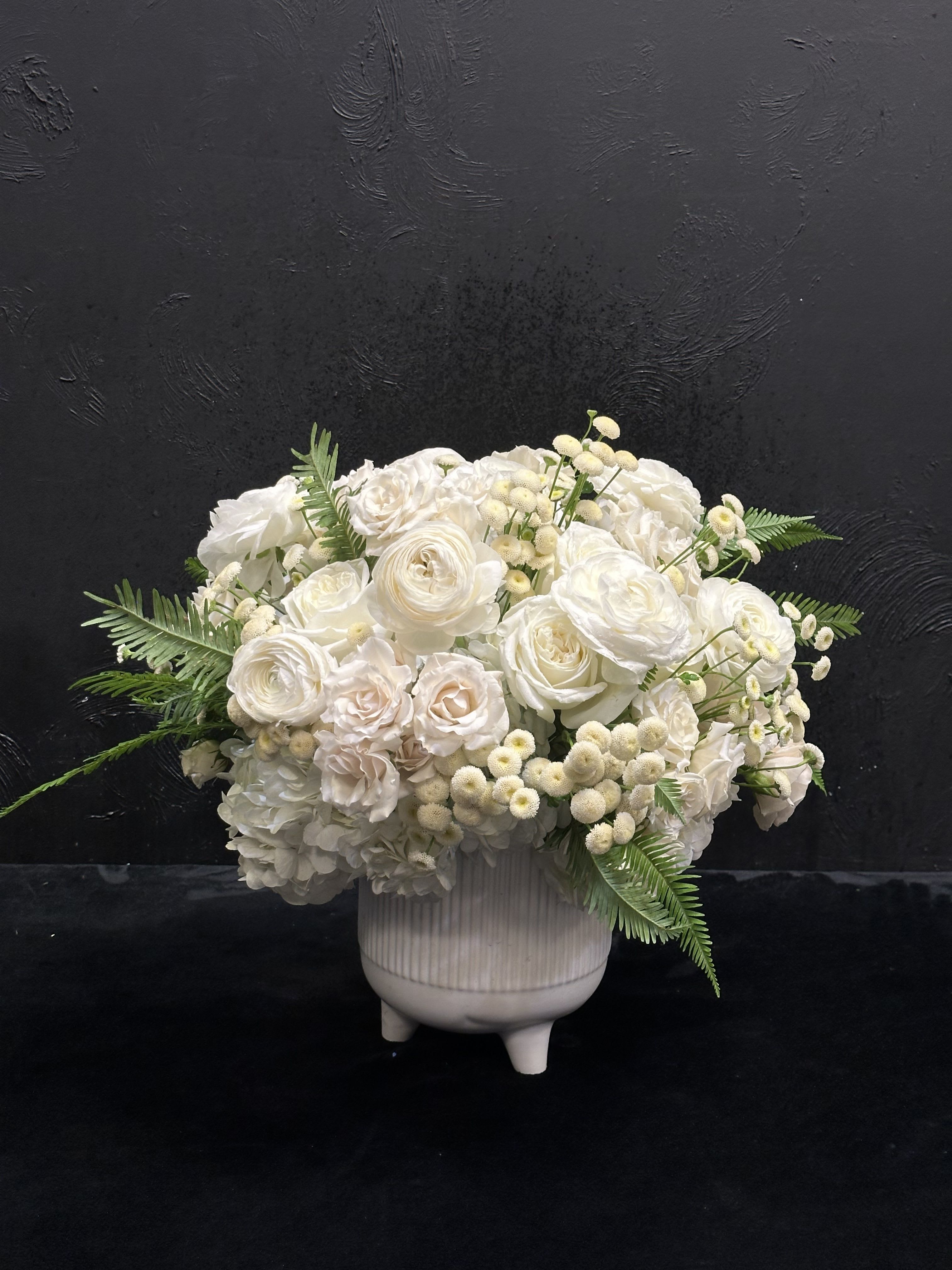 White floral arrangement in a ribbed ceramic vase