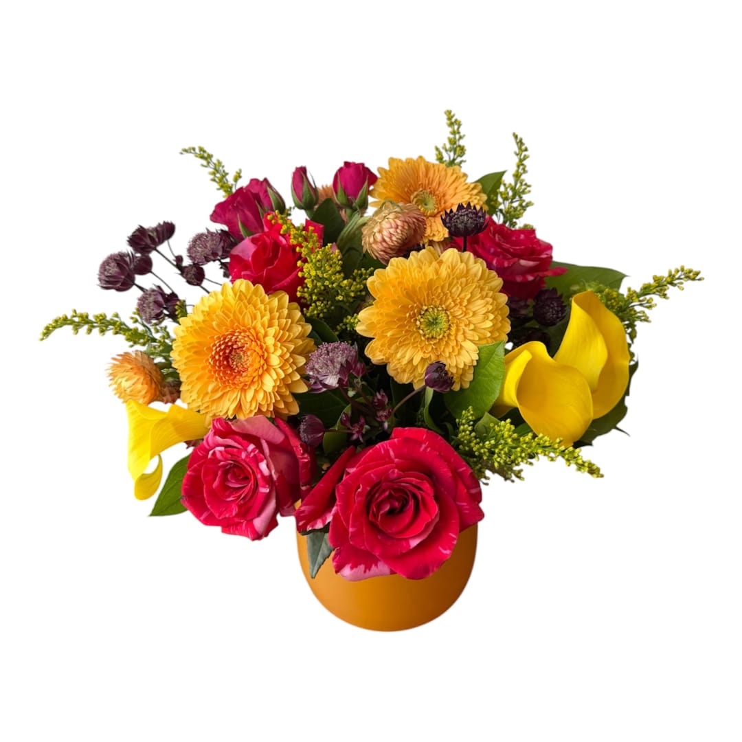 Mixed bouquet of pink roses, yellow gerberas, and yellow calla lilies in a vase