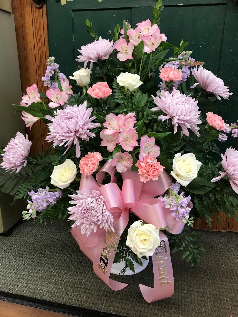 Pink and white floral arrangement with roses, carnations, and lilies in a vase