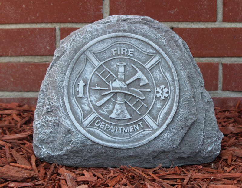 Fire department memorial stone in front of a brick wall