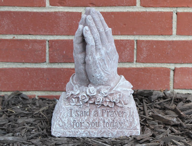 Prayer hands garden statue with floral detail and engraved text