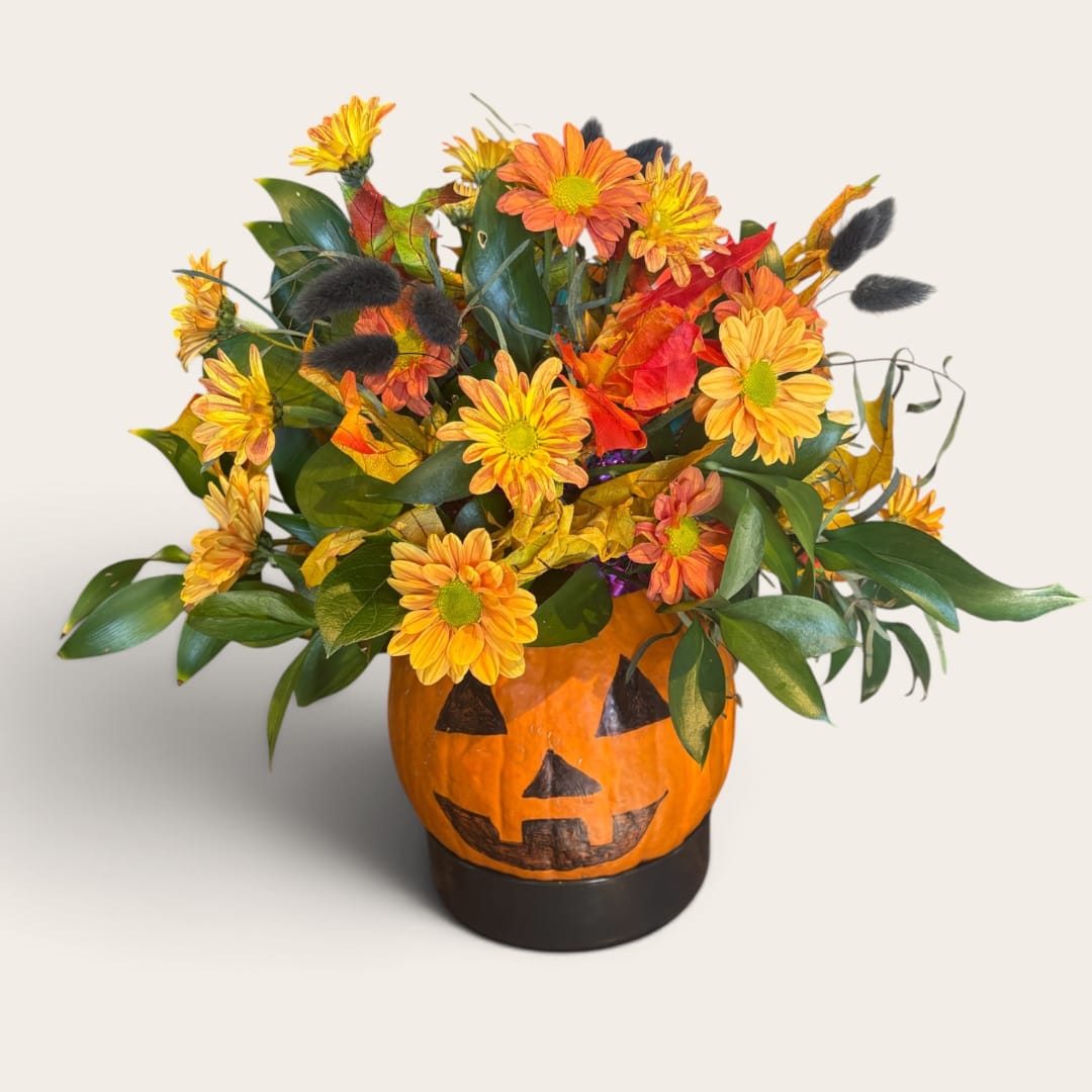 Fall floral arrangement in a painted jack-o'-lantern container