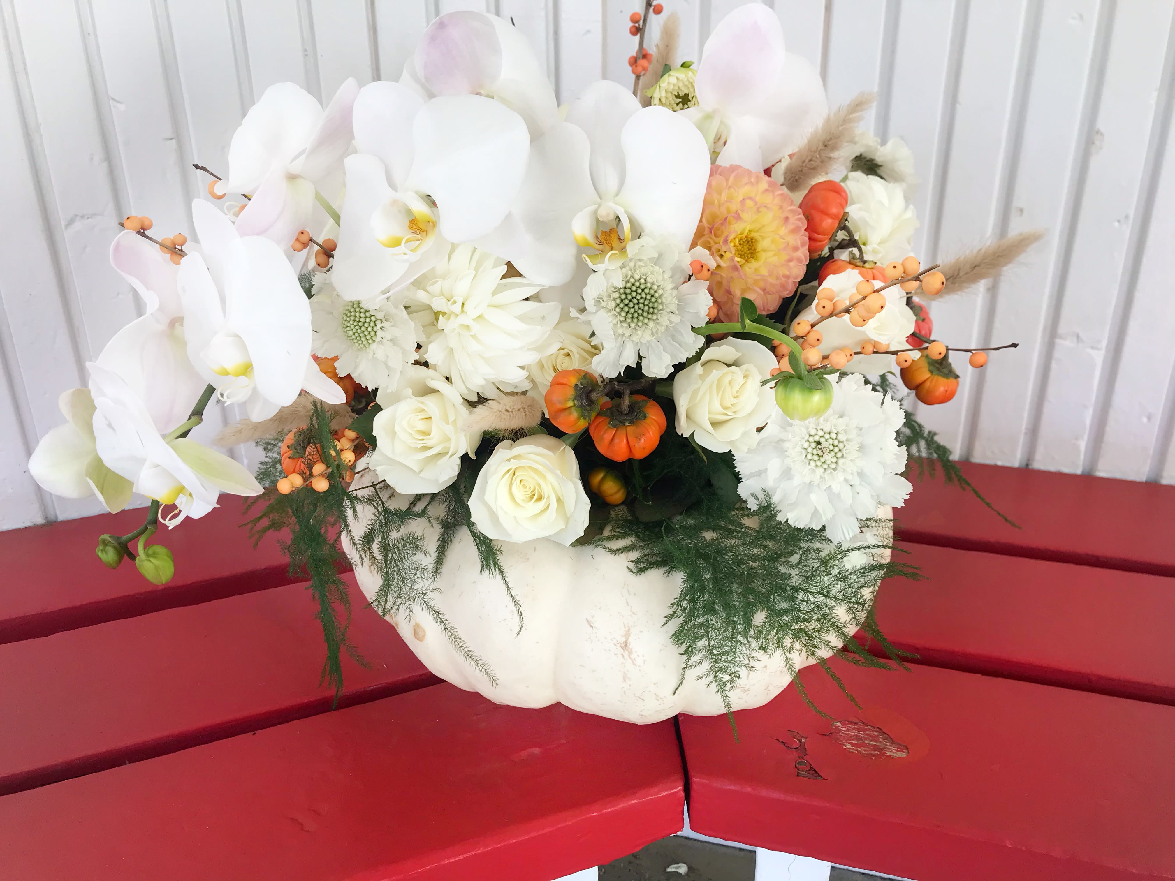 White orchid and rose arrangement in a white pumpkin container